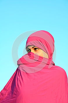 Muslim woman hiding behind scarf