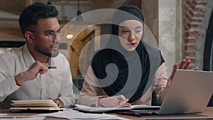 Muslim woman in hijab Arabian man working together with laptop talk discuss write notebook study online diverse students