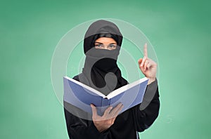 Muslim woman in hijab with book over white