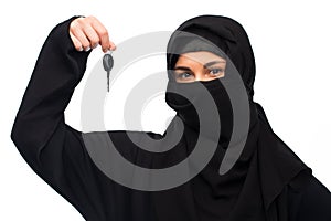 Muslim woman in hijab with car key over white