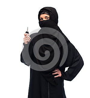 Muslim woman in hijab with car key over white