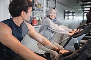 Muslim woman hijab and friend at the gym doing cardio exercises