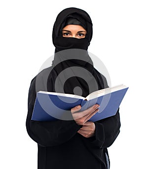 Muslim woman in hijab reading book over white