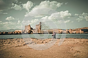 Muslim woman in hijab sitting on the river's bank