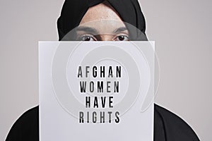 Muslim woman holding a paper with text - Afghan women have rights