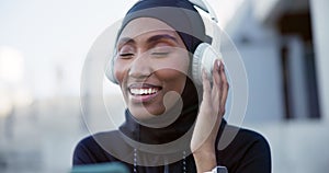 Muslim, woman and listening to music on headphones, tech or streaming radio, podcast or audio online with freedom. Happy