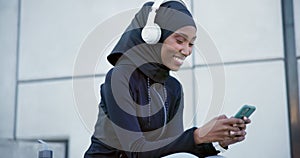 Muslim, woman and listening to music with phone, headphones or streaming radio, podcast and audio online. Happy, girl in