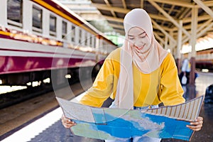 Muslim woman is looking at maps to plan their travel plans