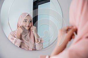 Muslim woman make up her self in the mirror