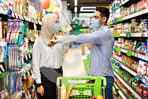 Muslim Woman And Man Bumping Elbows Shopping In Food Store