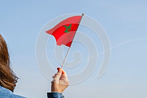 Muslim woman with Morocco flag on the blue sky. Concept.