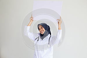 Muslim woman nurse smile isolated white background holding an empty white placard for insert a concept for advertisement,..