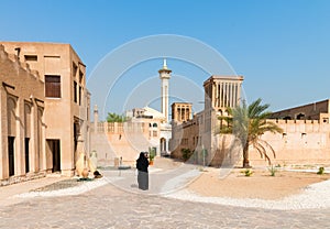 Muslim woman in old arabic district with mosque