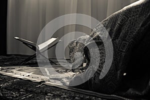 Muslim woman praying for Allah muslim god at room near window. Hands of muslim woman on the carpet praying in traditional wearing