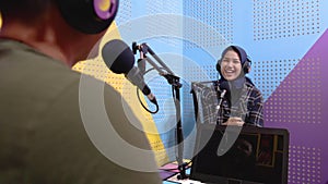 muslim woman recording podcast with a man in the studio