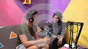 muslim woman recording podcast with a man in the studio