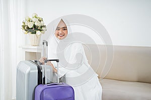 Muslim woman sit wearing white traditional clothes before umrah