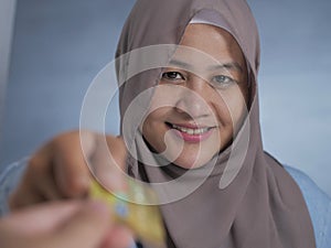 Muslim Woman Smiling When Receiving Credit Card