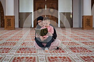 Muslim woman and son reading Koran, muslim family