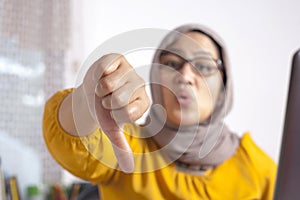Muslim Woman Thumbs Down, Dissapointed Expression photo