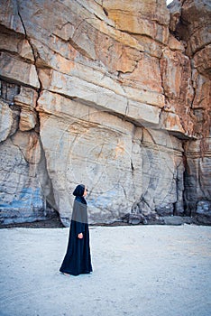 Muslim woman walking on the beach