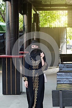 Muslim woman walking through empty street cafe before