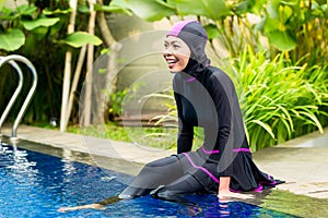 Muslim woman wearing Burkini swimwear at pool