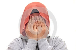 Muslim woman wearing hijab covering hiding face with her hands, shy afraid worried guilty gesture