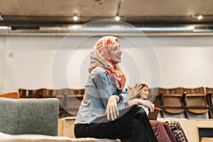 Muslim woman wearing hijab talking, sharing knowledge and experience with her colleagues during training session at work