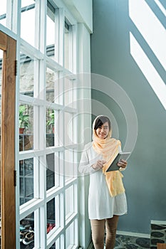 Muslim woman wearing hijab using tablet pc