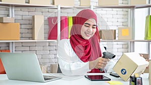 Muslim woman who owns a business, She inspects the product before sending the parcel for delivery to customers online.