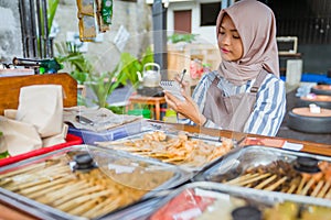 muslim woman write a report of her food business
