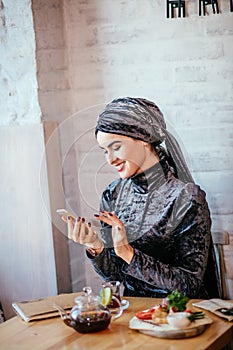 Muslim women holding smartphonephone. thinking of good memories.