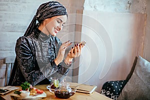 Muslim women holding smartphonephone. thinking of good memories.