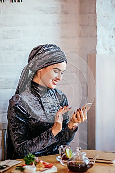 Muslim women holding smartphonephone. thinking of good memories.