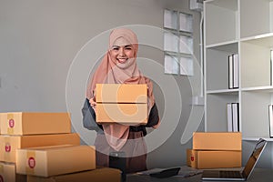 Muslim women selling online at home with box. Selling online with box to accept order from customer. SME business idea