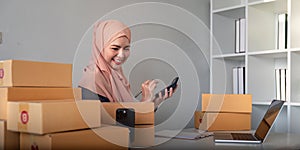 Muslim women selling online at home with box. Selling online with box to accept order from customer. SME business idea