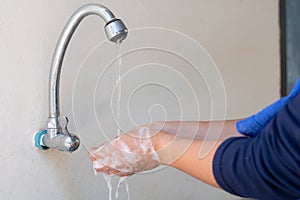 Muslim women wash hand with soap alcohol gel for sanitizer in kitchen sink concept for prevent Hygiene health care. Quarantine