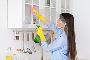 Muslim young woman cleaning shelfs at home at kitchen