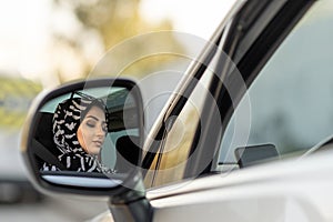 Muslim young woman is driving car carelessly