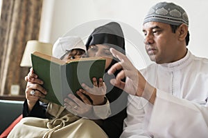 Muslims family reading the Quran together at home photo