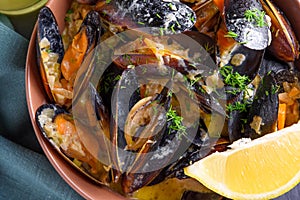 Mussels with celery and lemon slice in cream or beer, close-up view