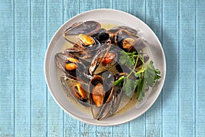 Mussels cooked on blue wooden table, top view photo