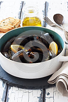 Mussels in copper pot preparing with thyme and lemon