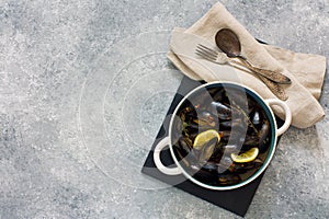 Mussels in copper pot preparing with thyme and lemon