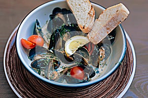 Mussels dish with some bread and little tomatoes