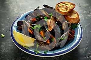 Mussels in garlic butter sauce served with parsley, toast and lemon