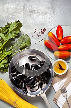 Mussels in a pan with the ingredients.