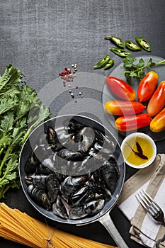 Mussels in a pan with the ingredients.