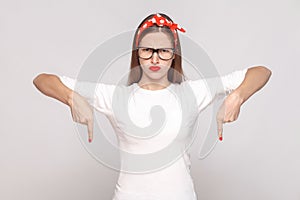 must be here right now. bossy anger portrait of beautiful emotional young woman in white t-shirt with freckles, glasses, red lips